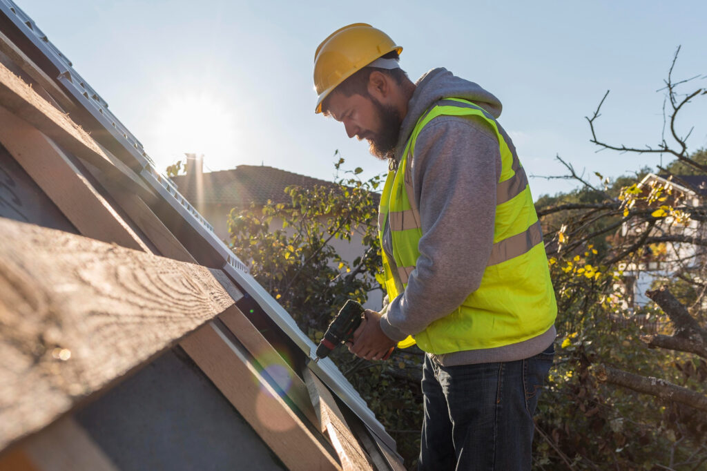 Construction worker installing roof shingles in sunlight