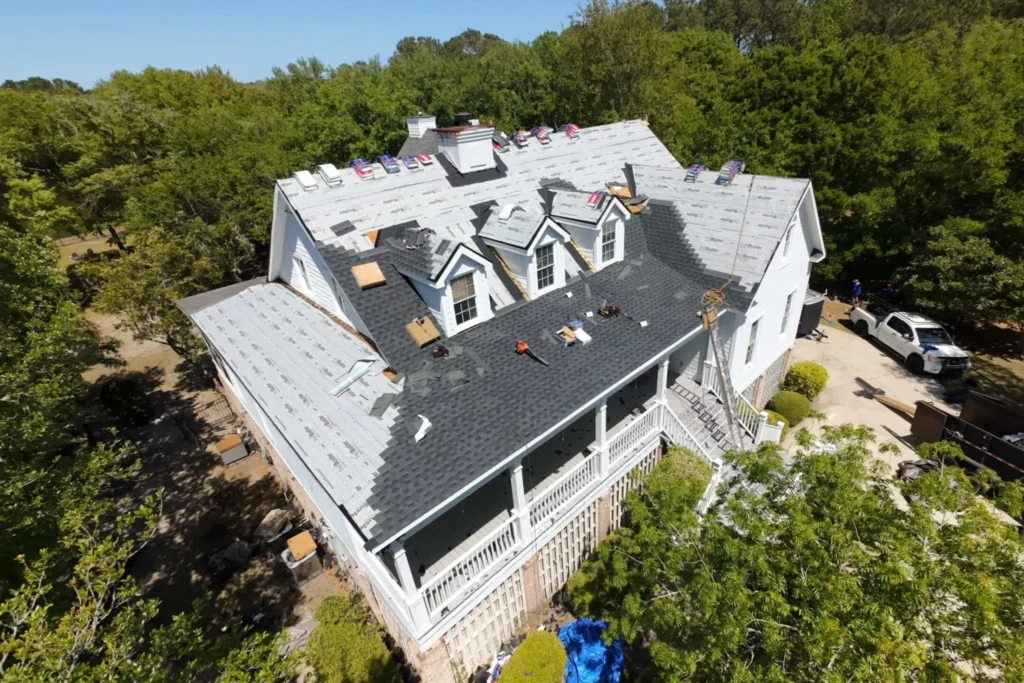 House with roof under construction surrounded by trees