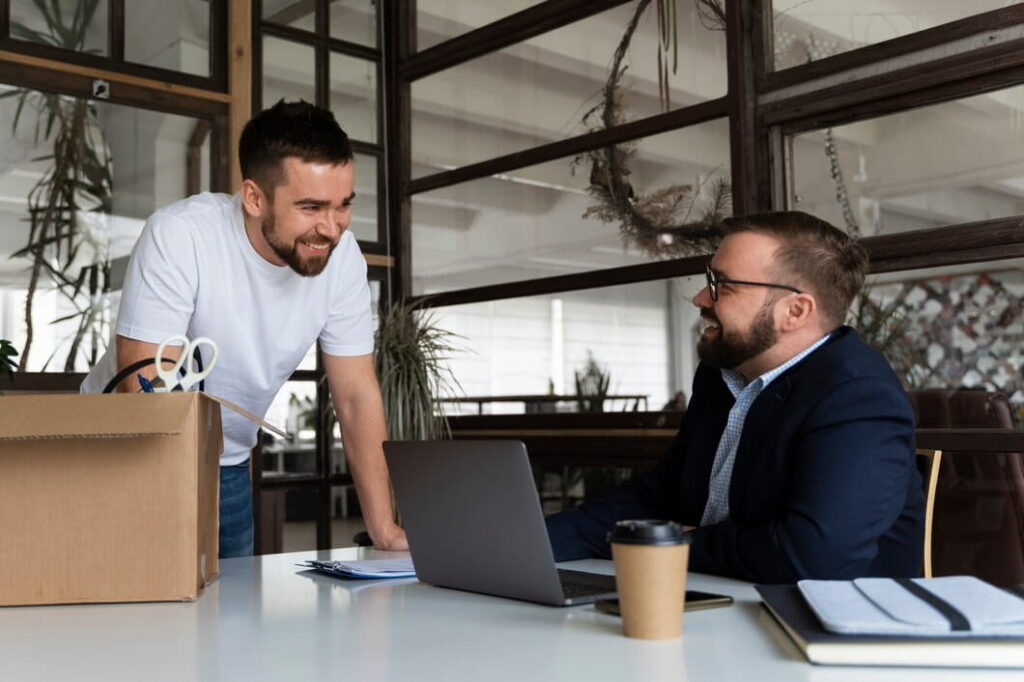 Two colleagues discussing work in a modern office setting